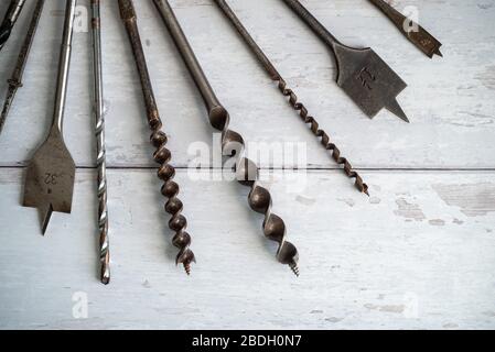Vintage tools. Vintage drill bits against a white wooden background Stock Photo