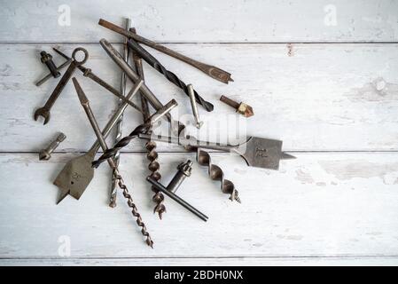 Vintage tools. Vintage drill bits against a white wooden background Stock Photo