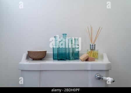 A collection of restful objects displayed on a clean white toilet cistern Stock Photo