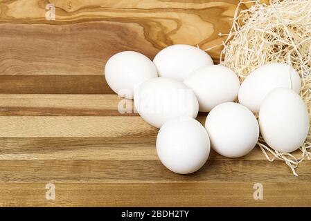 White chicken eggs and broken eggs on wooden board or table. Stock Photo