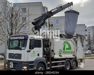 Heavy truck is lifting huge trash bag to empty it out Stock Photo