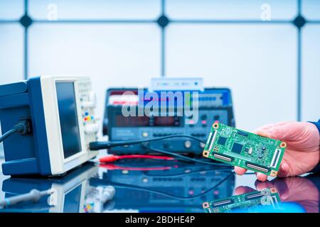 Debugging electronics device. PCB witch microcontroller in electronics laboratory Stock Photo
