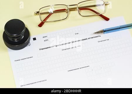 Document design, printing, glasses and pen on the table. Text in Russian ' Simplified accounting (financial) statements' Stock Photo