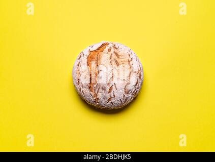 Freshly baked sourdough bread on a yellow seamless background. Wheat loaf without yeast flat lay. Traditional rustic bread. Stock Photo