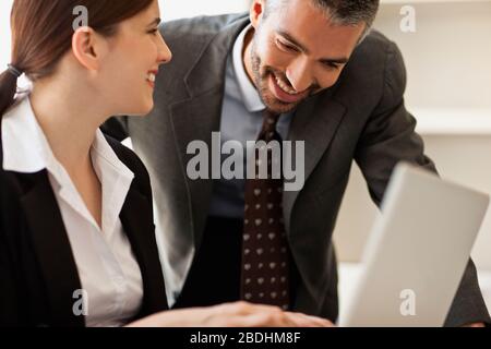 Two co-workers talking at desk. Stock Photo