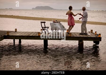 Mature couple enjoy dancing together on the pier. Stock Photo