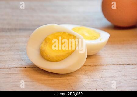 Close-up of hard boiled egg on wooden board Stock Photo