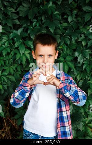 Happy boy making a heart shape with his hands Stock Photo