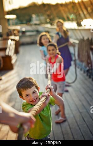 Family playing tug of war on ship deck. Stock Photo