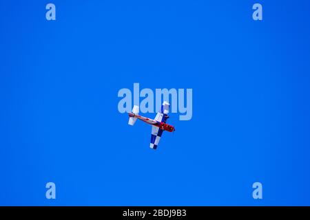 airplane model performs aerobatics in the sky, plane model against blue sky Stock Photo