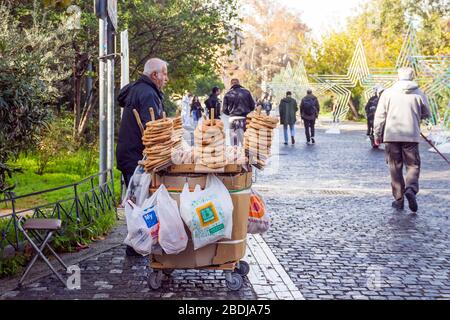 ATHENS, GREECE - DECEMBER 21, 2019: Man selling greek sesame bagel koulouri on Dionysiou Areopagitou pedestrian street in the touristic center of Athe Stock Photo