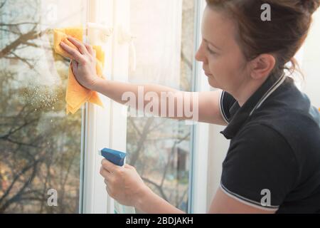 Beautiful woman cleaning window at home Stock Photo