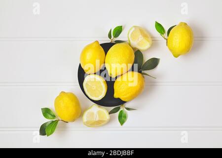 Composition with ripe lemons on white background. Close up. Stock Photo