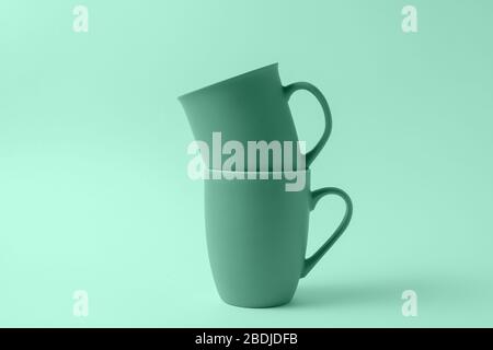 Flat lay Stack with mugs toned in light mint color on light mint background. Stock Photo
