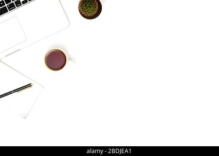 White table office desk with laptop, cup of coffee and supplies. Top view with copy space, flat lay. Stock Photo