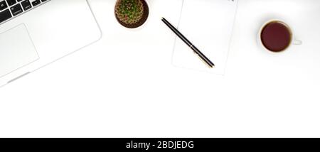 White table office desk with laptop, cup of coffee and supplies. Top view with copy space, flat lay. Stock Photo