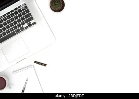 White table office desk with laptop, cup of coffee and supplies. Top view with copy space, flat lay. Stock Photo