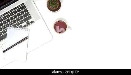White table office desk with laptop, cup of coffee and supplies. Top view with copy space, flat lay. Stock Photo