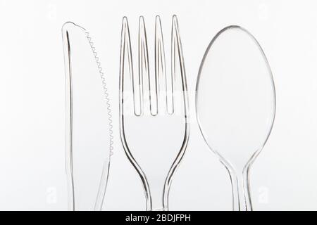 Close up of Transparent plastic Knife fork and spoon on a white background Stock Photo