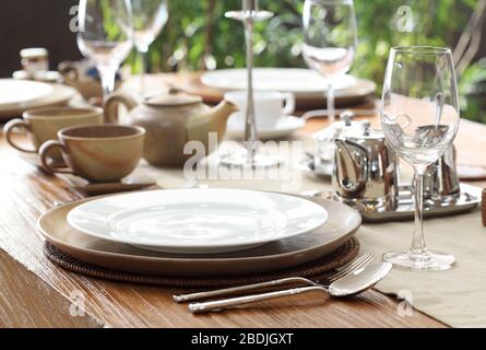 ethnic outdoor table setting on solid teak wood table Stock Photo