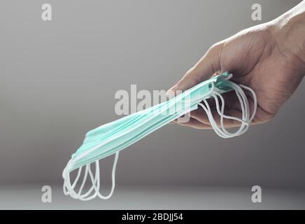 Hand giving a pile of medical protection masks Stock Photo