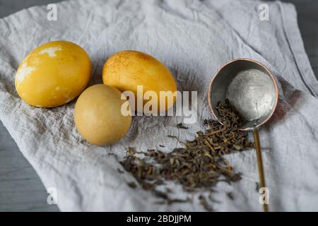 Easter eggs naturally dyed with green tea. Selective focus on vintage scoop. Stock Photo