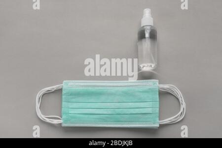 Top view of medical masks pile and Alcohol spray bottle on gray background Stock Photo