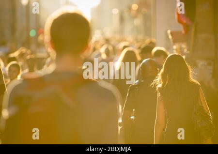 Crowd of unrecognizable pedestrians walking on a Oxford Street in golden summer light in London, UK Stock Photo