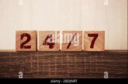 24/7 text on cubes on wooden background. Support clients concept Stock Photo