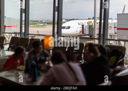 Toronto, Canada - July 30, 2019. Passengers wait in the departure lounge at Pearson International Airport. Stock Photo