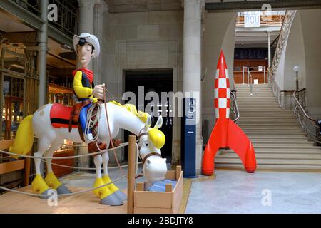 The statue of Lucky Luke and his horse Jolly Jumper and Tintin rocket display in the entrance hall of Belgian Comic Strip Center.Brussels.Belgium