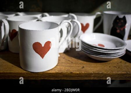 London, UK - 15 January 2020 White porcelain mugs and saucers with a red heart print Stock Photo