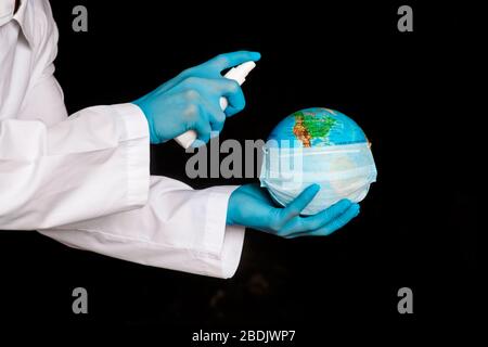 The concept is to protect the planet from coronavirus. splash the antiseptic on the globe. Covid-19 and the globe in the hands of the doctor Stock Photo