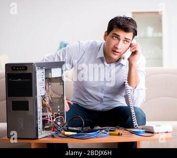 The angry customer trying to repair computer with phone support Stock Photo