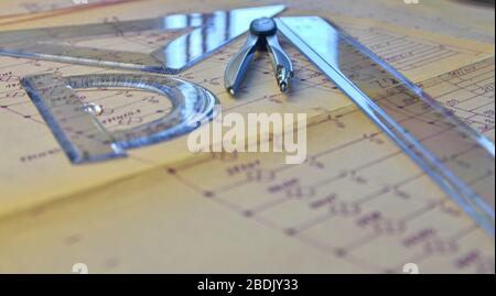 Electrical engineer workplace - electrotechnical project, rulers, and divider compass. Construction and electrotechnology concept. Engineering tools. Stock Photo