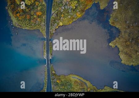 Top drone view of straight asphalt road running through majestic marsh on autumn day in Iceland Stock Photo