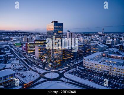 From above of modern city district with contemporary illuminated high buildings and traffic intersection in winter morning in Iceland Stock Photo