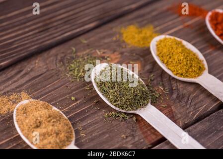 Assortment of colorful spices in the wooden spoons. Stock Photo