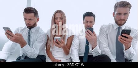 close up.Business people using smartphones sitting in a row Stock Photo