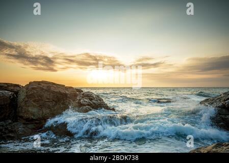 Tropical colorful sunset at the stones beach in summer. Stock Photo