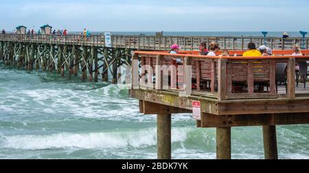 People enjoying the casual beachfront dining experience of the Funky Pelican at the Flagler Beach Pier in Flagler Beach, Florida. (USA) Stock Photo