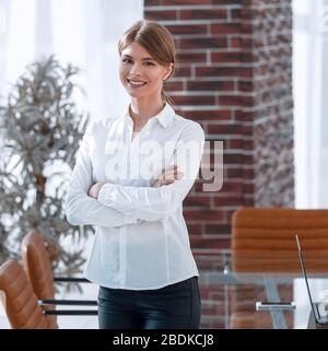 confident young woman standing near desktop Stock Photo