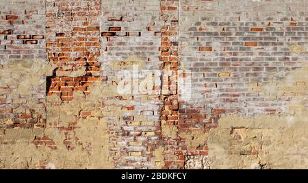 Closeup of an old brick wall, in parts crumbling away, multi-coloured bricks Stock Photo