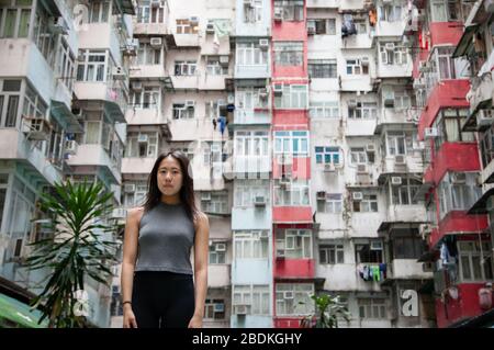 Chinese girl exploring the urban landscape of Hong Kong's crammed public housing quarters in Quarry Bay on Hong Kong Island Stock Photo