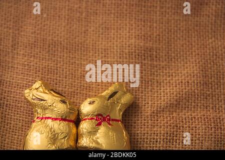 Flat lay of a pair of easter rabbits facing each other on burlap cloth with room for text. Decoration Stock Photo