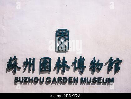 Suzhou China - May 3, 2010: Closeup of Black letters and symbols on white wall for Suzhou Garden Museum. Sun provokes shadows. Stock Photo