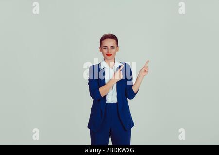 Smiling corporate lady pointing away to copy space light green background wall Stock Photo
