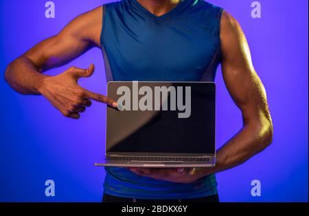 Fitness Guy Showing Laptop Empty Screen On Blue Background, Cropped Stock Photo