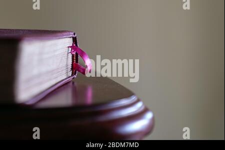 Book with pink book mark on the side of wood table. Space for text. Stock Photo