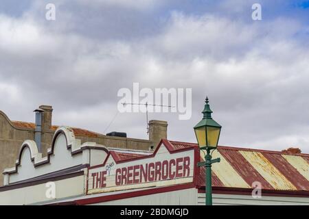 Clunes Australia - March 15 2020; Traditional street lamp and greengrocer shop sign on facade of traditional style buildings. Stock Photo